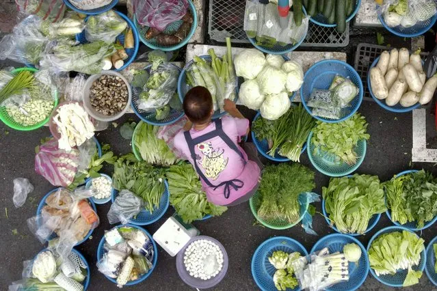 A vendor sorts her vegetables at Wanda road traditional market in Taipei on January 25, 2022. (Photo by Sam Yeh/AFP Photo)