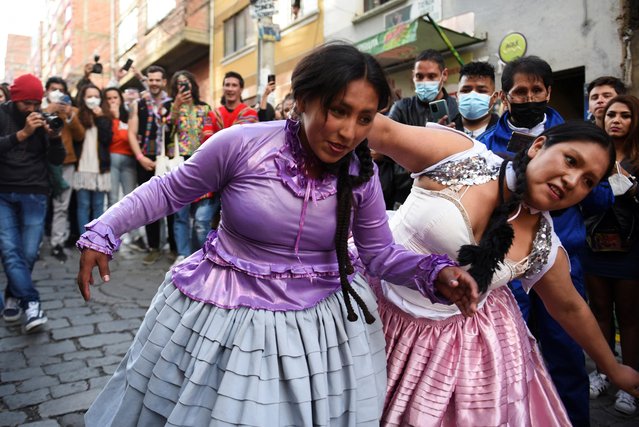 Cholita wrestlers stage a performance on the street during the Electropreste celebration, which combines traditional and modern customs, in La Paz, Bolivia on March 12, 2022. (Photo by Claudia Morales/Reuters)