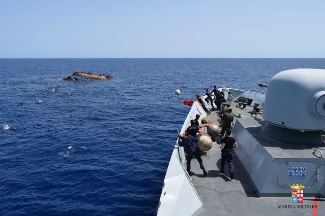 An Italian Navy ship approaches an overturned boat off the Libyan coast, Wednesday, May 25, 2016. (Photo by Marina Militare via AP Photo)