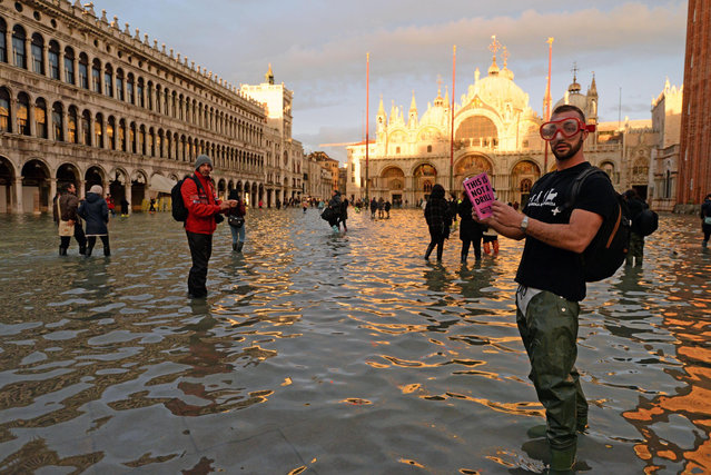 Tourists are seen in flooded St. Mark's Square in Venice, northern Italy, 17 November 2019. (Photo by Andrea Merola/EPA/EFE)