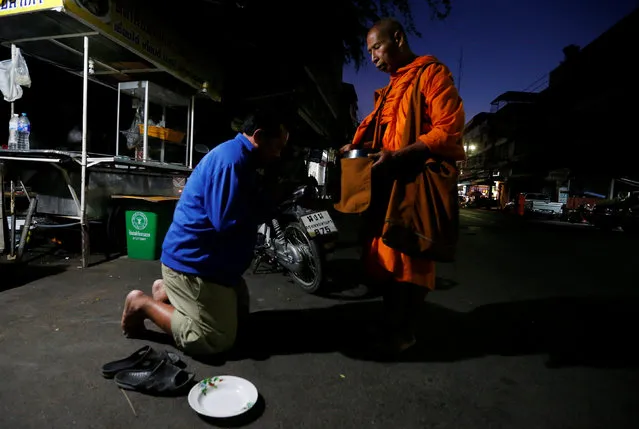A Buddhist monk receives food from people in Nonthaburi province, on the outskirts of Bangkok, Thailand February 8, 2017. (Photo by Chaiwat Subprasom/Reuters)