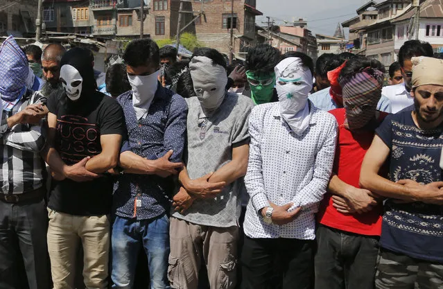 Masked Kashmiri Muslims hold funeral prayers in absentia for rebel commander and his associate killed in a gunbattle, in Srinagar, India, Saturday, May. 27, 2017. One civilian was killed and dozens of others injured Saturday after massive anti-India protests and clashes erupted in Indian-controlled Kashmir following the killing of a prominent rebel commander and his associate in a gunbattle with government forces in the disputed region. (Photo by Mukhtar Khan/AP Photo)