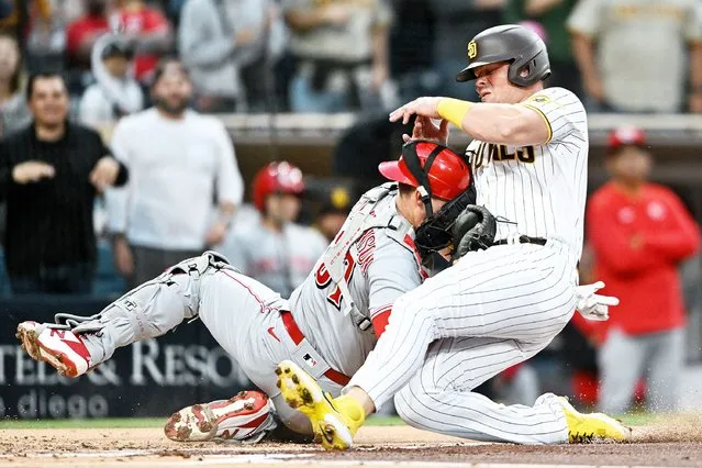 Luke Voit #45 of the San Diego Padres collides with Tyler Stephenson #37 of the Cincinnati Reds at home plate during the second inning of a baseball game at Petco Park on April 19, 2022 in San Diego, California. Voit was out on the play. (Photo by Denis Poroy/Getty Images)