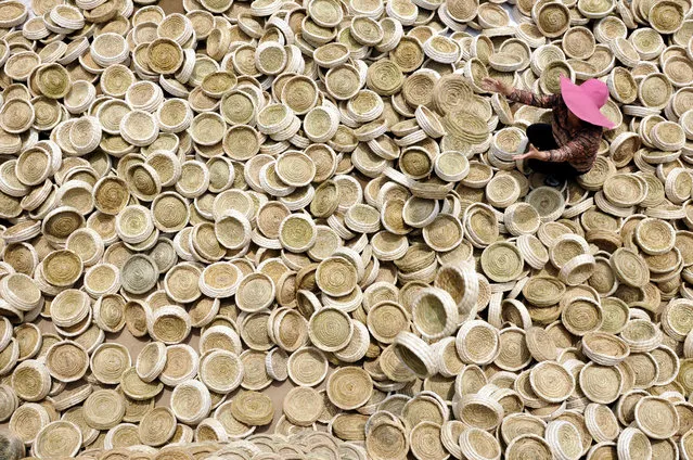 A worker puts aside handicrafts of bird nests as she sits among them in Linyi, Shandong Province, China, May 30, 2016. (Photo by Reuters/Stringer)