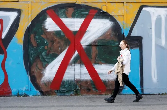A woman walks past artwork in support of Ukraine, as Russia's invasion of Ukraine continues, London, Britain, March 24, 2022. (Photo by Peter Cziborra/Reuters)