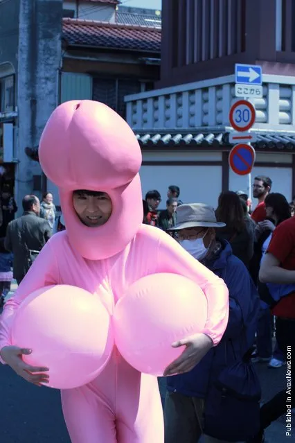 A woman dressed dressed as a pink phallus walks in the street during festivities for the Kanamara festival (Festival of the Steel Phallus) on April 1, 2012 in Kawasaki, Japan