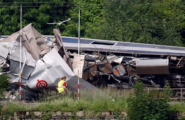 An official inspects the wreckage of a passenger train after it crashed into the back of a freight train, in the eastern Belgian municipality of Saint-Georges-Sur-Meuse, June 6, 2016. (Photo by Francois Lenoir/Reuters)