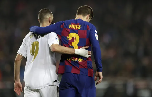 Real Madrid's Karim Benzema, left, and Barcelona's Gerard Pique walks together on the pitch during a Spanish La Liga soccer match between Barcelona and Real Madrid at Camp Nou stadium in Barcelona, Spain, Wednesday, December 18, 2019. Thousands of Catalan separatists are planning to protest around and inside Barcelona's Camp Nou Stadium during Wednesday's “Clasico”. (Photo by Bernat Armangue/AP Photo)