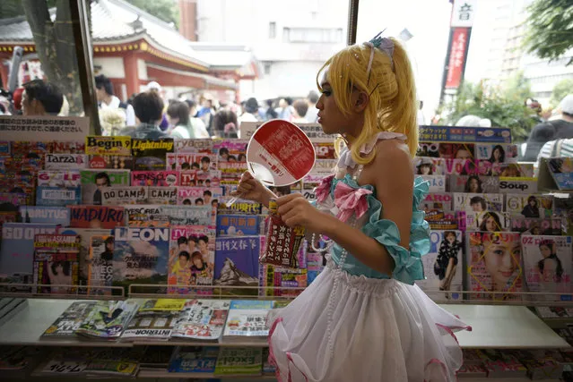 A cosplayer shops in a convenience store before the Osu Cosplay Parade held as part of the World Cosplay Summit (WCS) 2015 in Nagoya, central Japan, 02 August 2015. Apart from participants from 26 countries that attended the WCS championship, hundreds of cosplay fans displayed their costumes at the parade. Cosplay, short for 'costume and play', is a Japanese subculture in which cosplayers wear costumes representing manga, anime or video games characters. (Photo by Franck Robichon/EPA)