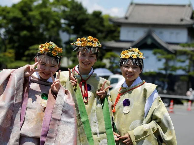 Participants dressed in ancient Japanese costumes pose for photos as they take part in a parade at the Imperial Palace during the Sanno Festival in Tokyo, Japan June 10, 2016. (Photo by Toru Hanai/Reuters)