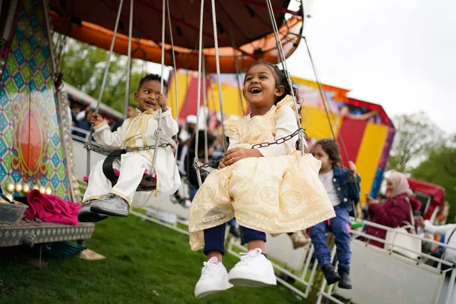 Children enjoy theme park rides at a funfair at Small Heath Park in Birmingham on Monday, May 2, 2022, as the holy month of Ramadan comes to an end and Muslims celebrate Eid al-Fitr. (Photo by Jacob King/PA Wire)