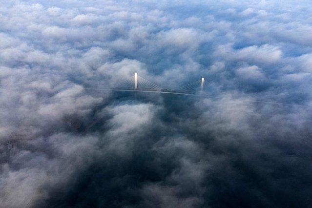 An aerial view shows the Mohammad Baqir al-Sadr bridge on a foggy morning in Iraq's southern city of Basra on December 17, 2023. (Photo by Hussein Faleh/AFP Photo)