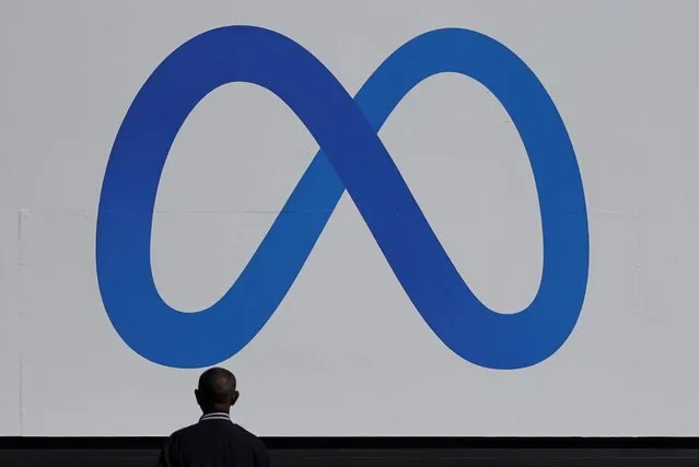 A man stands in front of a sign of Meta, the new name for the company formerly known as Facebook, at its headquarters in Menlo Park, California, U.S. October 28, 2021. (Photo by Carlos Barria/Reuters)