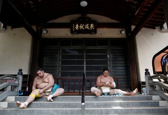 Brazilian-born sumo wrestler Kaisei (L), and Mongolian-born sumo wrestler Kyokushuho tape up during a training session in Nagoya, Japan on July 18, 2017. Entering the world of sumo is to eat, live, and breathe Japanese – from the samurai-style topknots to the rigid hierarchy. (Photo by Issei Kato/Reuters)