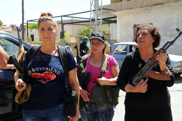 Women pose with guns in front of journalists in the Christian village of Qaa, where suicide bomb attacks took place on Monday, in the Bekaa valley, Lebanon June 28, 2016. (Photo by Hassan Abdallah/Reuters)