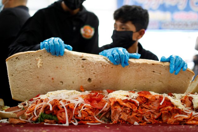 People participate in an event to set a new record for the longest sandwich ever made, measuring 75.20 meters long, in Mexico City, Mexico on August 2, 2023. (Photo by Raquel Cunha/Reuters)