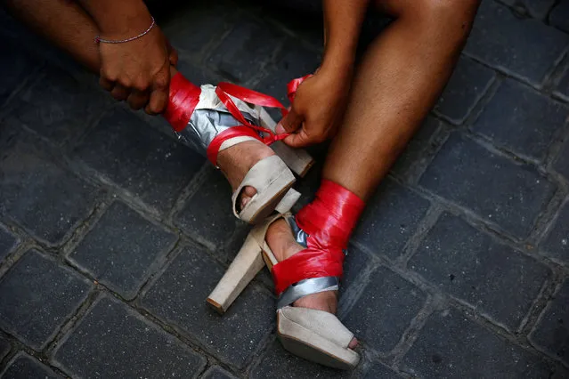 A competitor removes tape from his shoes after taking part in the annual race on high heels during Gay Pride celebrations in the quarter of Chueca in Madrid, Spain, June 30, 2016. (Photo by Susana Vera/Reuters)