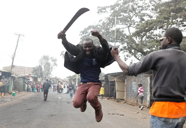 A supporter of opposition leader Raila Odinga gestures with a machete in Kibera slum in Nairobi, Kenya, August 11, 2017. (Photo by Goran Tomasevic/Reuters)