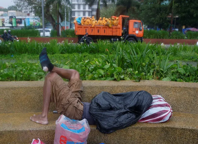 A man sleeps on a bench amidst bad weather brought by Typhoon Nepartak in Manila, Philippines July 8, 2016. (Photo by Erik De Castro/Reuters)