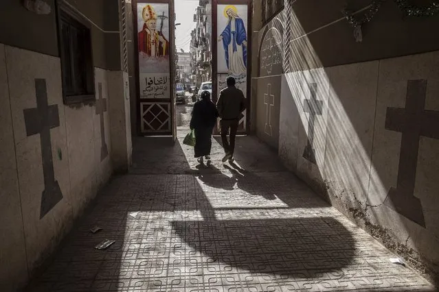 In this Tuesday, January 6, 2015 file photo, Coptic Christians walk outside St. Markos Church in Minya, south of Cairo, Egypt. A Muslim mob ransacked and torched seven Christian homes in a province south of the Egyptian capital, Cairo, after rumors spread that a Christian man had an affair with a Muslim woman, according to a statement by the local Orthodox Coptic church. Released late Wednesday, it said that during the May 20, 2016 attack, the mother of the Christian man, who had fled the village, was publicly stripped of her clothes by the mob to humiliate her. (Photo by Roger Anis/AP Photo)