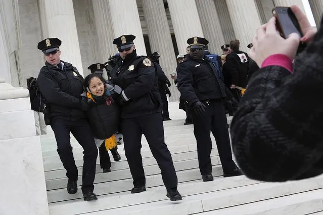 Police arrest demonstrators after they tore down a barricade and took to the steps of the U.S. Supreme Court building in Washington, in this file photo taken January 20, 2012. A U.S. appeals court on Friday upheld a federal law banning protests on the marble plaza directly in front of the U.S. Supreme Court in Washington, saying demonstrators are free to protest nearby. (Photo by Jonathan Ernst/Reuters)