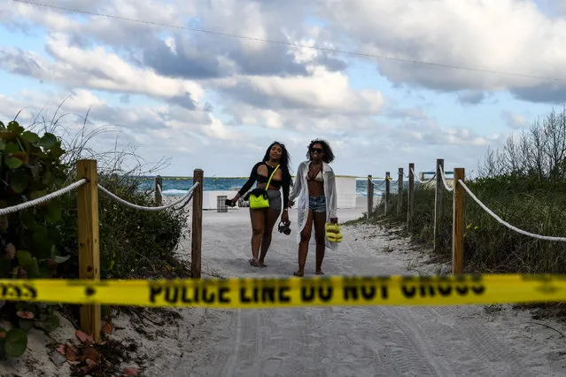 Tourists trespass at the closed Miami Beach in Miami, on March 19, 2020. The Miami Beach mayor, Dan Gelber, warned of “devastating consequences” over the virus and ordered bars and gyms to close this week, telling springbreakers: “You've got to think about the person next to you and even the person you don't know”. (Photo by Chandan Khanna/AFP Photo)