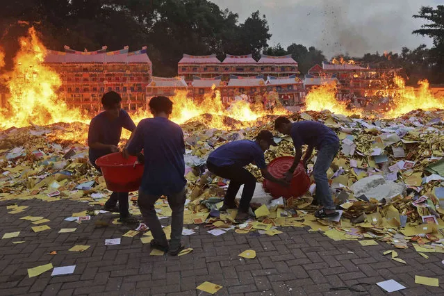 Ethnic Chinese people burn imitation money known as “hell money” during the Hungry Ghost Festival in Medan, North Sumatra, Indonesia, Friday, August 12, 2022. (Photo by Binsar Bakkara/AP Photo)