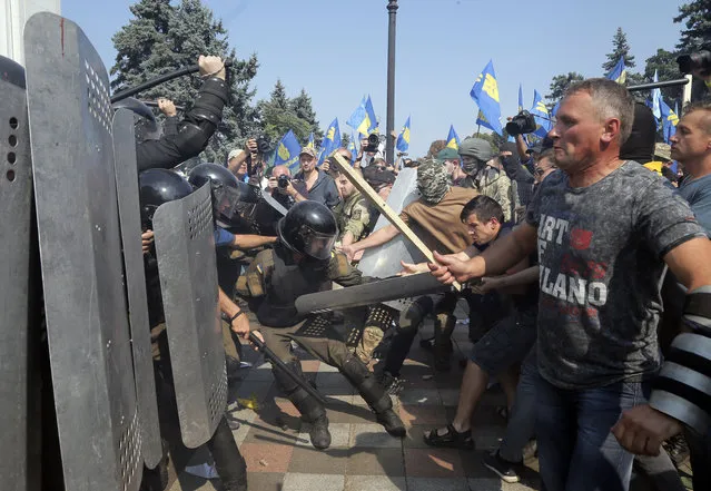 Ukrainian protesters clash with police after a vote to give greater powers to the east, outside the Parliament, Kiev, Ukraine, Monday, August 31, 2015. (Photo by Efrem Lukatsky/AP Photo)