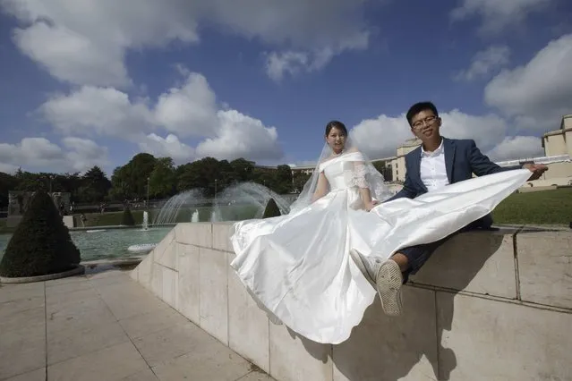 A Chinese couple poses during a pre-wedding photoshoot near the Eiffel tower in Paris, France, August 28, 2015. (Photo by Philippe Wojazer/Reuters)