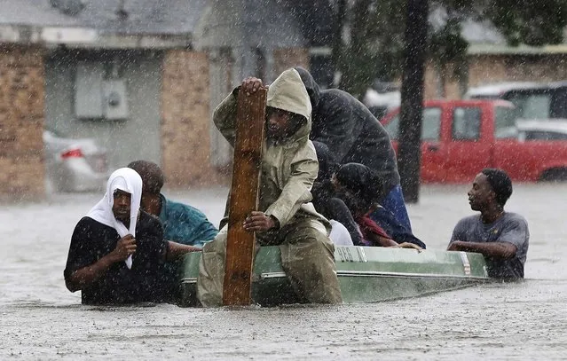 Residents evacuate their flooded neighborhood in LaPlace, Louisiana on Thursday.  Isaac staggered toward central Louisiana, its weakening winds still potent enough to drive storm surge into portions of the coast and the River Parishes between New Orleans and Baton Rouge. (Photo by Eric Gay/Associated Press)
