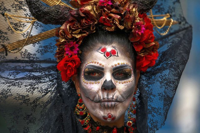 A disguised reveller takes part in the Sao Paulo Zombie Walk in Sao Paulo, Brazil, on November 2, 2023. Hundreds of people took to the streets in traditional costumes of zombies, witches, vampires, and horror characters during the Zombie Walk SP, held every year since 2006 on the Day of the Dead. (Photo by Miguel Schincariol/AFP Photo)