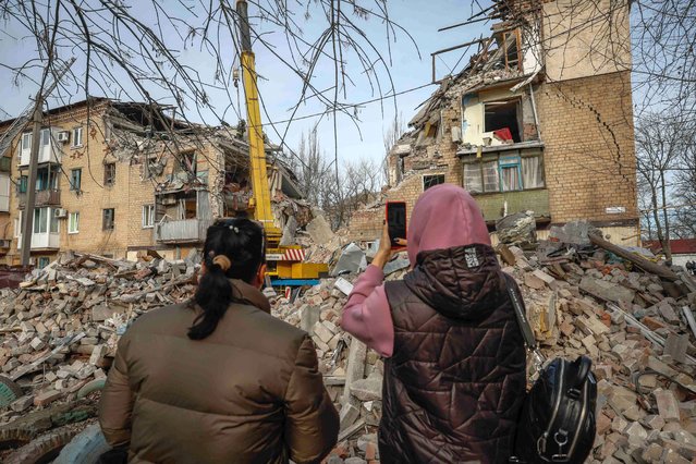 Local residents photograph the result of a Russian missile strike at the site of damaged residential house, amid Russia's attack on Ukraine, in the town of Selydove, Donetsk region, Ukraine on November 15, 2023. (Photo by Alina Smutko/Reuters)