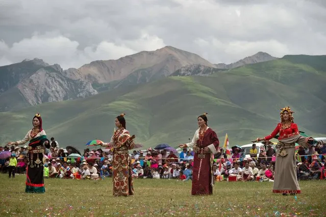 In this picture taken on July 26, 2016 ethnic Tibetan models wear traditional costumes and fine jewellery during a fashion show at a local government sponsored festival in Yushu, in the northwestern Chinese province of Qinghai. The festival held since the 1990s lasts for around five days. It was suspended for several years following a 2010 earthquake in Yushu which killed some 2,700 people. (Photo by Nicolas Asfouri/AFP Photo)