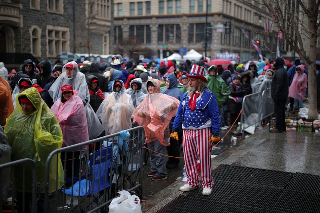 A man dressed as Uncle Sam looks on as supporters line up outside Capital One Arena, ahead of a rally for U.S. President-elect Donald Trump the day before he is scheduled to be inaugurated for a second term, in Washington, U.S., January 19, 2025. (Photo by Daniel Cole/Reuters)