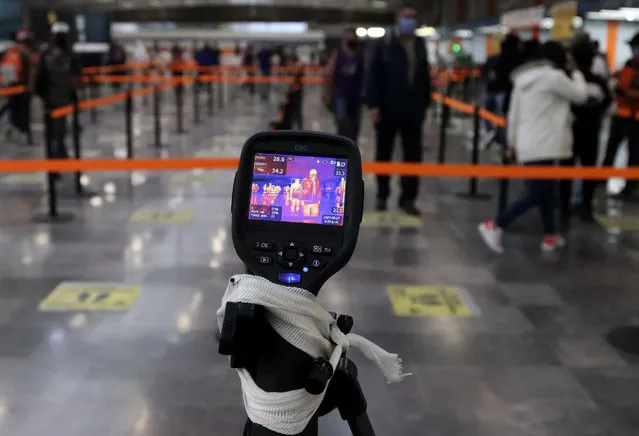 A thermal scanner checks commuters' temperature during the Metro Collective System's implementation of dosing measures, at the four-way station in Mexico City, Mexico 27 May 2020. The Mexican health authorities reported on 27 May an increase in coronavirus cases. (Photo by Jose Pazos/EPA/EFE/Rex Features/Shutterstock)
