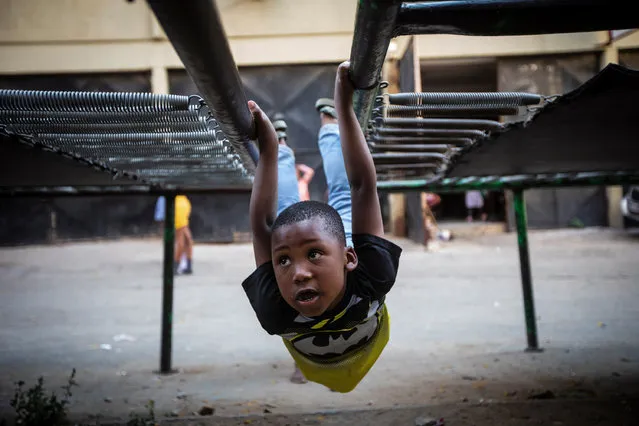 A boy enjoys his afternoon fun on one of the three public trampolines in the Alexandra township in Johannesburg, South Africa, 22 September 2022. The children jump after school each day as one of the rare extra activities in one of Johannesburg oldest and most impoverished townships. Life in the township has been even harsher of late with the crime levels increasing, unemployment of the rise and load shedding effecting the small businesses that are part of the macro economic environment. (Photo by Kim Ludbrook/EPA/EFE)