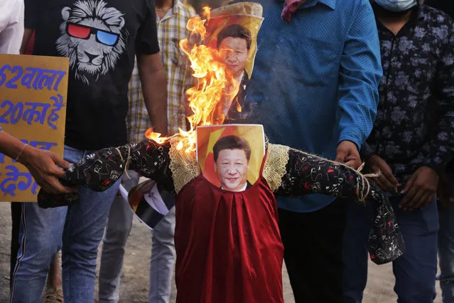 Indians burn an effigy of Chinese President Xi Jinping during a protest against China in Ahmedabad, India, Thursday, June 18, 2020. Twenty Indian troops were killed in a clash with Chinese soldiers in the Galwan Valley area Monday night that was the deadliest conflict between the sides in 45 years. (Photo by Ajit Solanki/AP Photo)