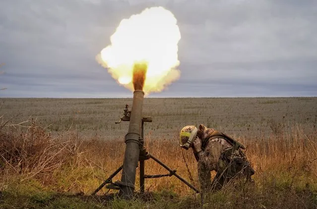 Ukrainian National guard soldiers fire at Russian positions with a mortar near Kharkiv, Ukraine, Tuesday, October 25, 2022. (Photo by Andrii Marienko/AP Photo)