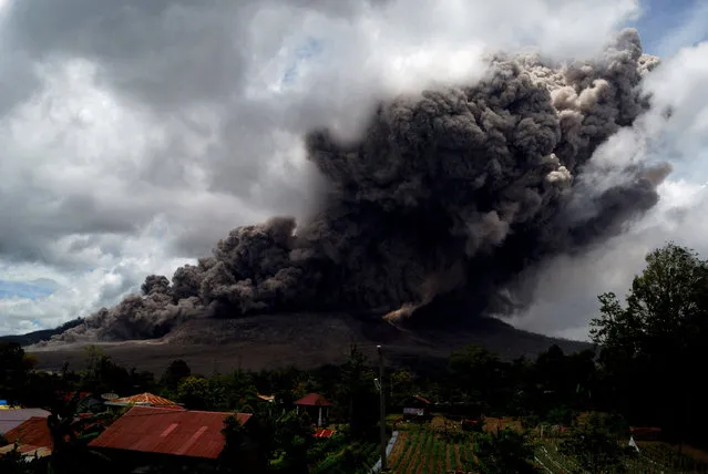 Dark giant ash clouds rise from the crater of Mount Sinabung volcano during an eruption on October 8, 2014, as seen from Karo district located on Indonesia's Sumatra island, following an earlier eruption on October 5, 2014. (Photo by Sutanta Aditya/AFP Photo)