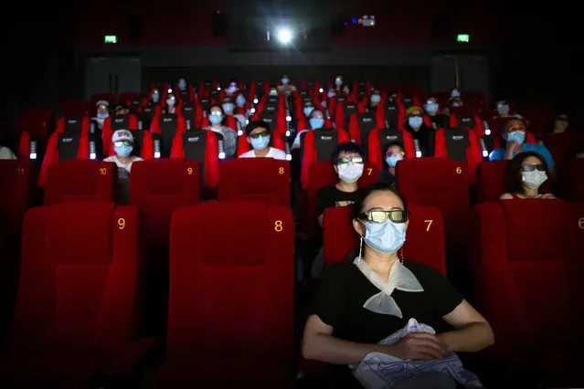 People wearing face masks to protect against the coronavirus sit spaced apart as they watch the film “Dolittle” at a movie theater in Beijing, Friday, July 24, 2020. Beijing partially reopened movie theaters Friday as the threat from the coronavirus continues to recede in China’s capital. (Photo by Mark Schiefelbein/AP Photo)
