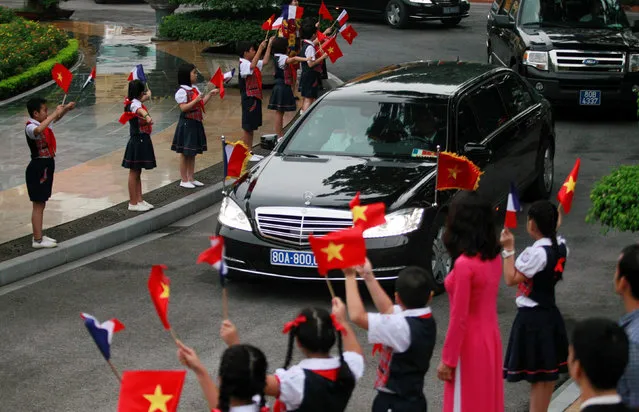 Vietnamese children wave Vietnamese and French flags as a limousine carrying France's President Francois Hollande arrives for a welcoming ceremony at the Presidential Palace in Hanoi, Vietnam September 6, 2016. (Photo by Reuters/Kham)