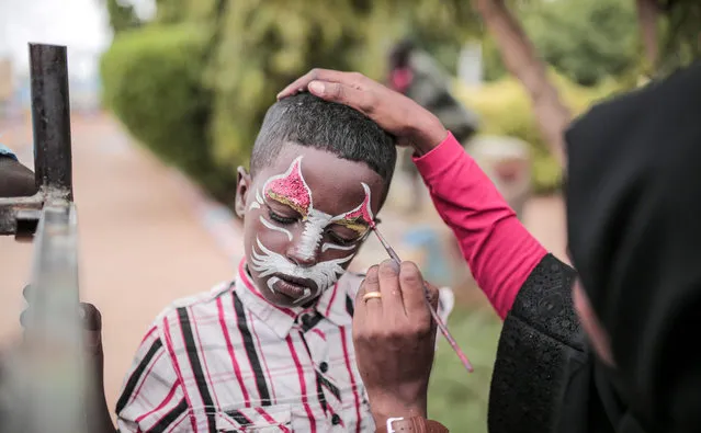 A Sudanese childs has the face painted at an amusement park in Omdurman, the capital Khartoum’s twin city, on August 13, 2019. Known as the “big” festival, Eid Al-Adha is celebrated each year by Muslims sacrificing various animals according to religious traditions, including cows, camels, goats and sheep. The festival marks the end of the Hajj pilgrimage to Mecca and commemorates Prophet Abraham's readiness to sacrifice his son to show obedience to God. (Photo by Jean Marc Mojon/AFP Photo)