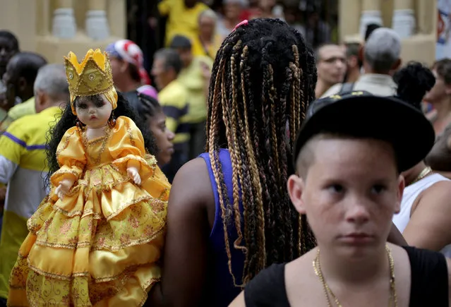 A woman holds a doll representing the Lady of Charity during the annual procession of the patron saint of Cuba in Old Havana, Cuba, September 8, 2016. (Photo by Enrique De La Osa/Reuters)