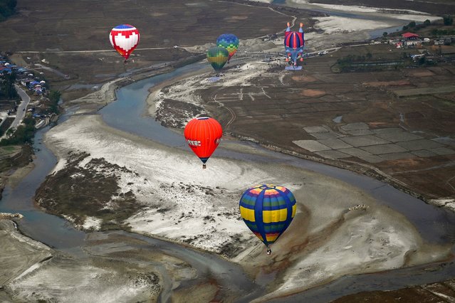 Hot air balloons rise in the sky during the International Hot-Air Balloon festival in Pokhara on December 24, 2024. (Photo by Prakash Mathema/AFP Photo)