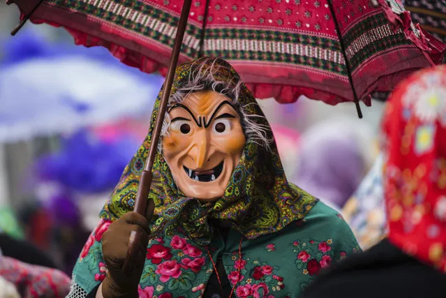 A participant dressed as a witch enjoys the carnival parade in Wuerzburg, southern Germany, Sunday, February 11, 2018. (Photo by Nicolas Armer/DPA via AP Photo)