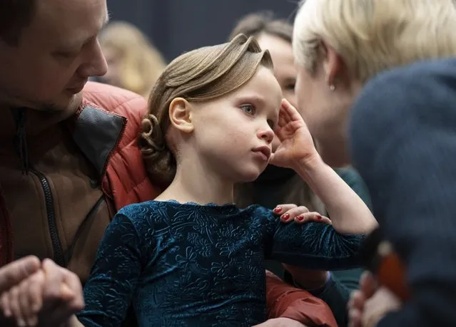 Alice, 7, reacts as her parents calm her down after performing at a dance festival in Kyiv, Ukraine, Saturday January 28, 2023. (Photo by Roman Hrytsyna/AP Photo)