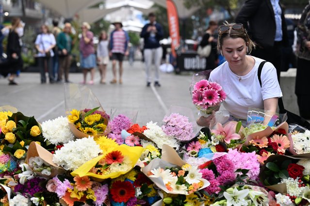 A woman pays her respects and lay flowers at the scene of the 13 April stabbing rampage at Bondi Junction in Sydney, Australia, 14 April 2024. The man who fatally stabbed six people in an attack at a Sydney shopping center has been identified as 40-year-old Joel Cauchi, who moved to Sydney from Queensland last month. (Photo by Dean Lewins/EPA/EFE)