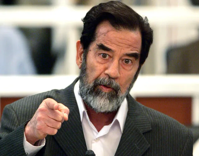Former Iraqi leader Saddam Hussein speaks as his trial in the  heavily fortified courtroom in Baghdad's Green Zone  Wednesday October 19, 2005. Nearly two years after he was found in hiding, former Iraqi leader Saddam Hussein goes on trial Wednesday charged with crimes against humanity. (Photo by Bob Strong/AP Photol)