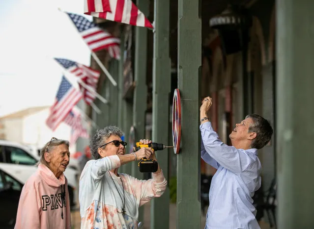 Kim Fuller, a niece of former U.S. President Jimmy Carter, and LeAnne Smith, a niece of former U.S. First Lady Rosalynn Carter, place painted peace symbols along the storefronts in downtown Plains, Georgia, U.S., February 22, 2023. “It's a symbol of what he stands for”, says LeAnne Smith. (Photo by Alyssa Pointer/Reuters)