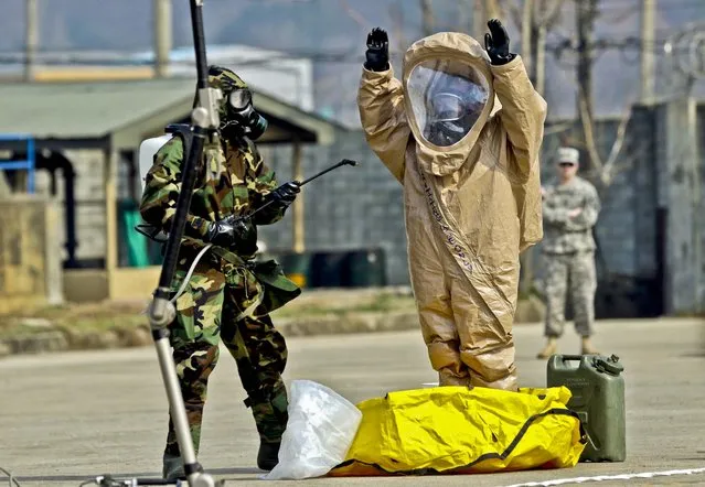 U.S. Army soldiers conduct a demonstration of their equipment at a ceremony to recognize the battalion's official return to  Camp Stanley, north of Seoul, on April 4, 2013. The 23rd chemical battalion left South Korea in 2004 and returned with some 350 soldiers in January. The soldiers will provide nuclear, biological and chemical detection, equipment decontamination and consequence management assistance to support the U.S. and South Korean military forces. (Photo by Lee Jin-man/Associated Press)